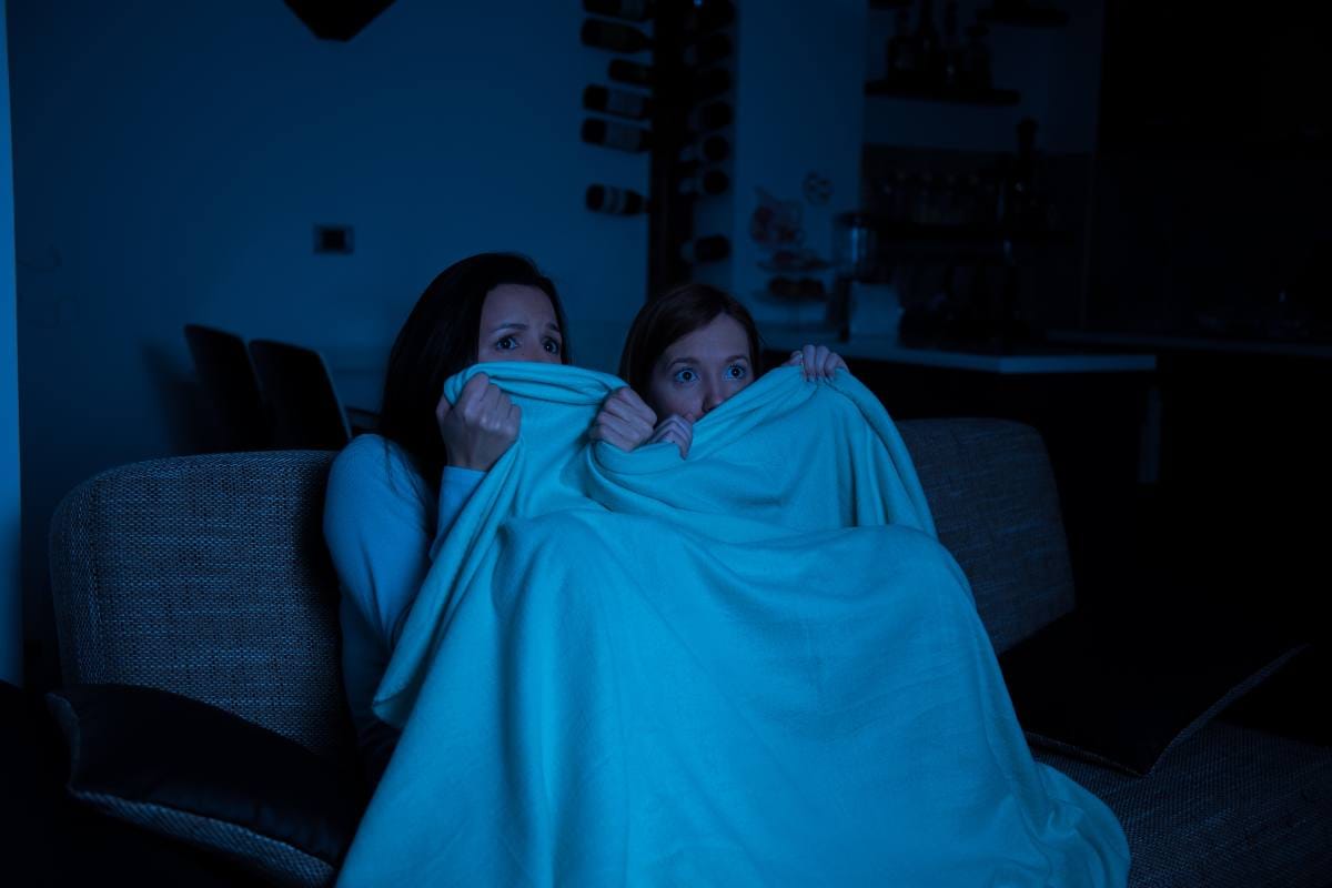 duas adolescentes assustadas assistindo filmes de terror